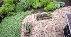 A flagstone patio from above with many plants and trees