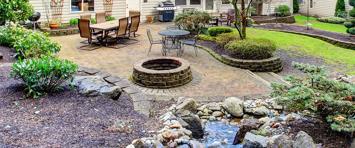 A large outdoor space with a small pond and fireplace