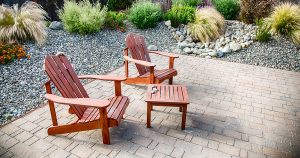 A paver patio with two wood chairs and small table
