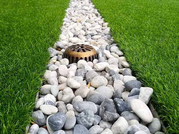 Closeup of french drain installation on a green lawn