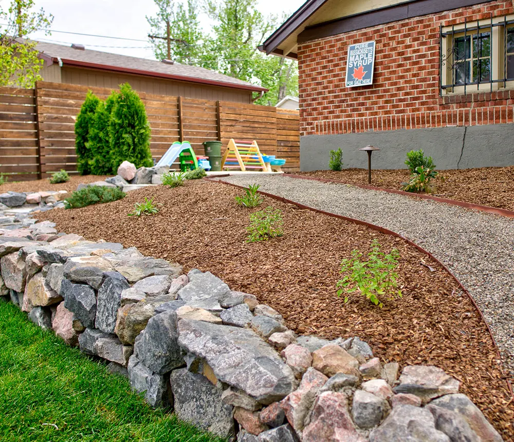 Closeup of a retaining wall for a small house with custom landscape and shrubs