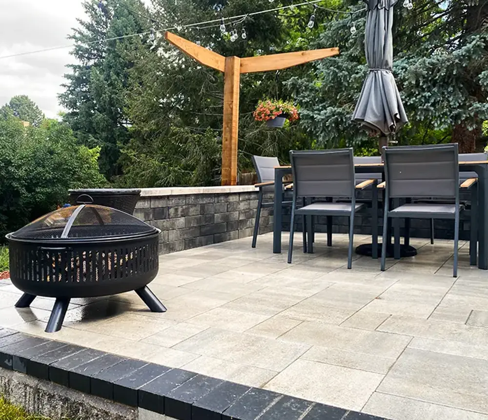Paver patio with two-color pavers and black border with fire pit and sitting area