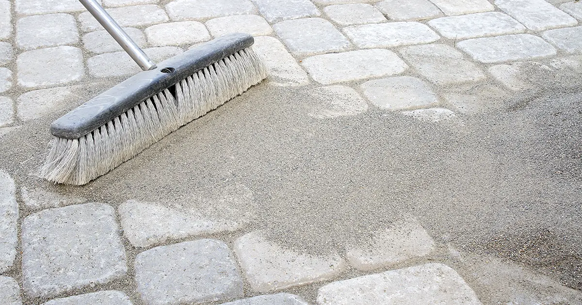 Brushing sand over newly installed patio
