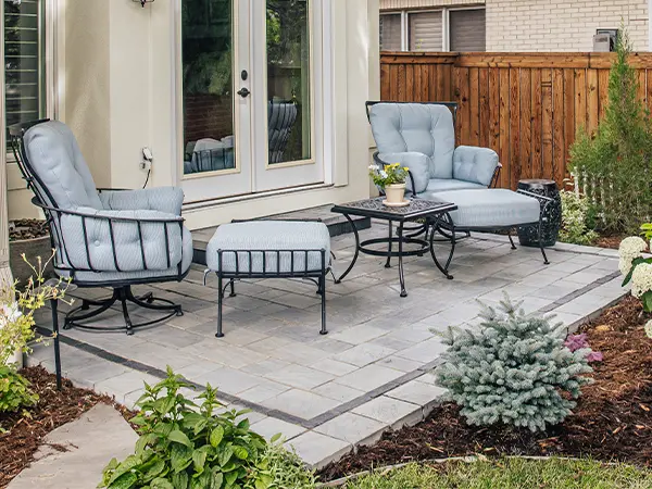 Paver patio with gray outdoor furniture in backyard