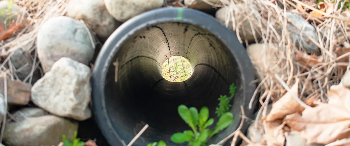 Looking Through a French Drain With a Black Pipe and Rocks Surrounded it