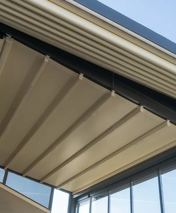 Close-up of a motorized pergola's retractable roof system with metal frames and glass walls