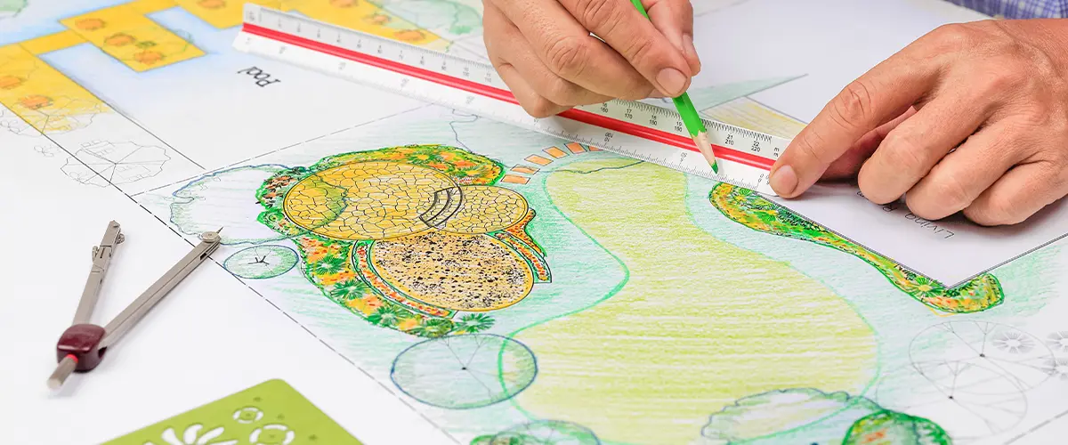 Landscape architect drawing a detailed garden design plan with precision tools and colorful sketches.