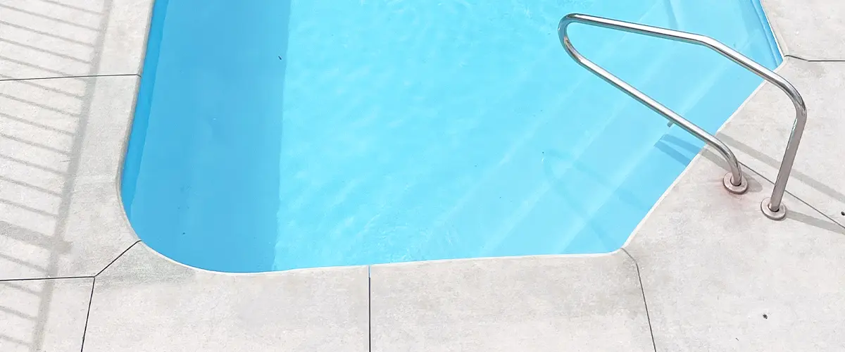 Concrete pool with a clean minimalist design around a swimming pool