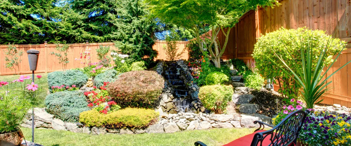 Beautiful backyard with a serene water feature surrounded by lush plants.