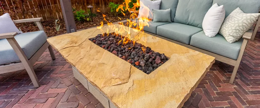 Modern backyard patio with fire pit, cushioned seating, and paver flooring for outdoor living space design