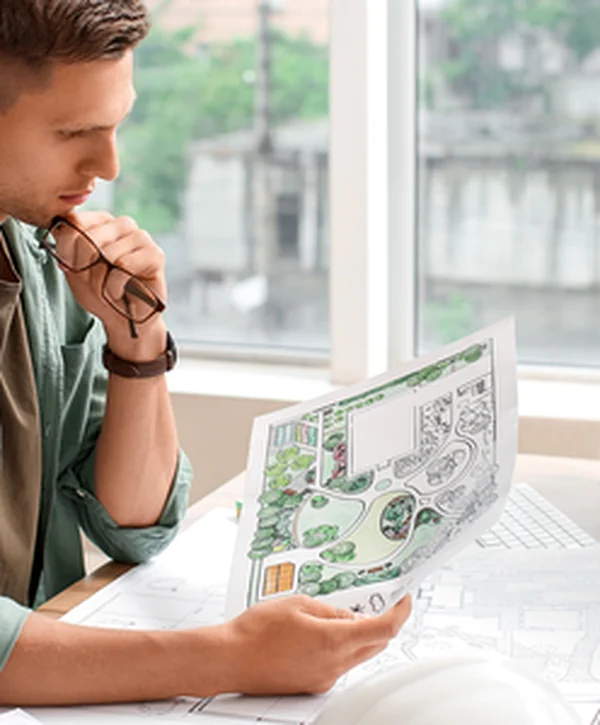 landscape architect belcaro denver co landscaping hardscaping expert landscape architect reviewing detailed design plans at computer workstation