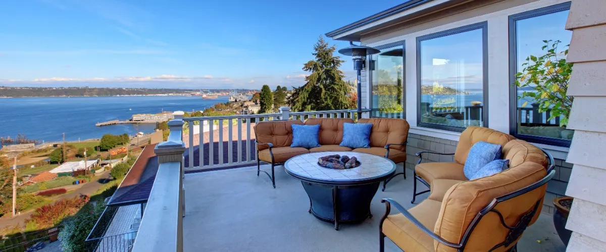 A patio with chairs and a table, offering a scenic view of the water.