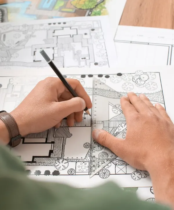 A person sketches on paper with a pencil, focused on their drawing.