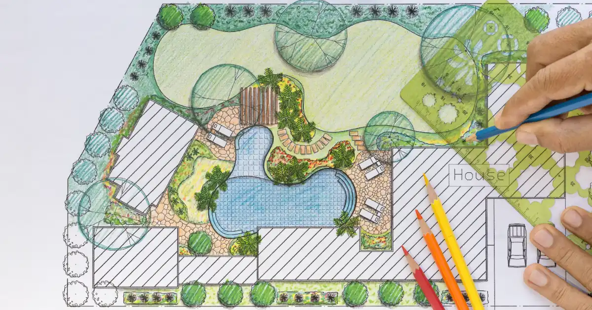 a person sketching a landscape design plan for a residential property