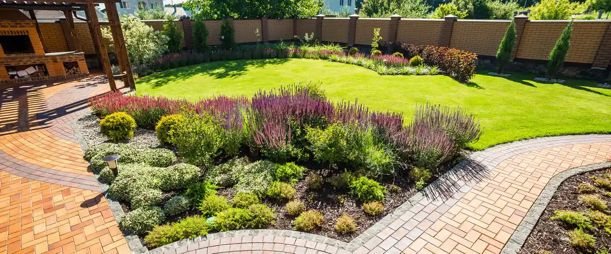 Lush backyard garden landscape featuring artistic stone pathways and vibrant perennial plants.